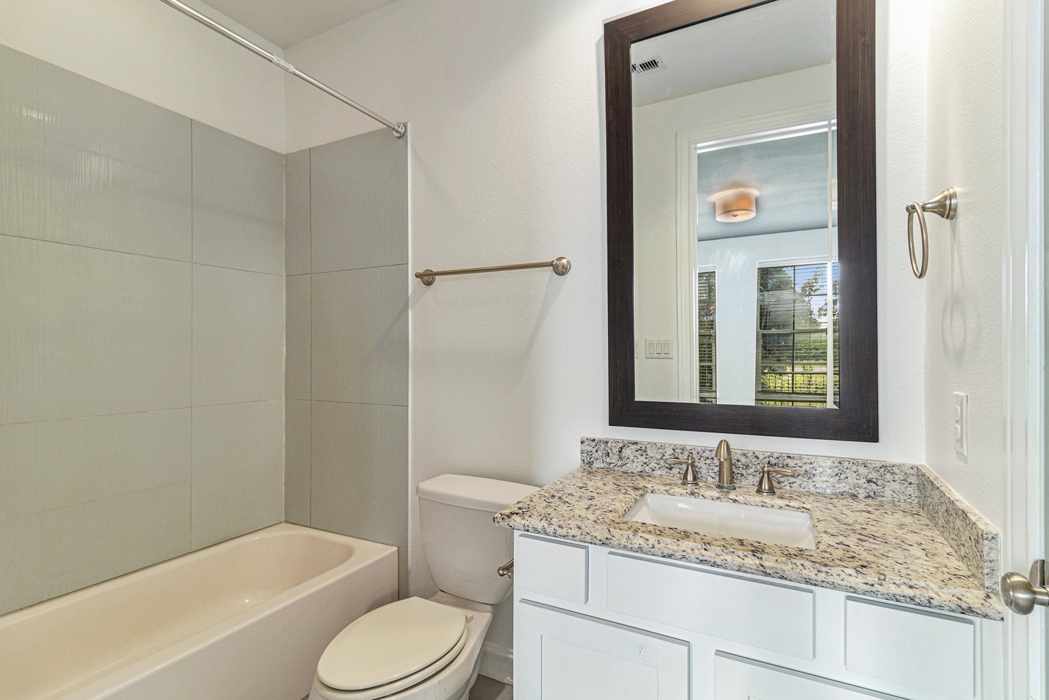 9674 Knight Road Houston, TX 77045 - Photo 14 of 21 a bathroom with a granite countertop toilet sink and mirror