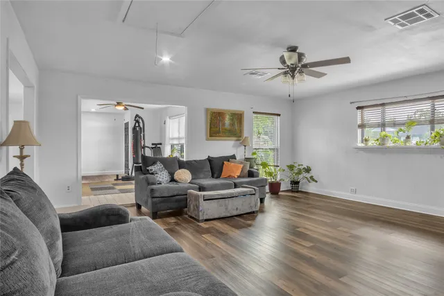 a living room with furniture and a wooden floor