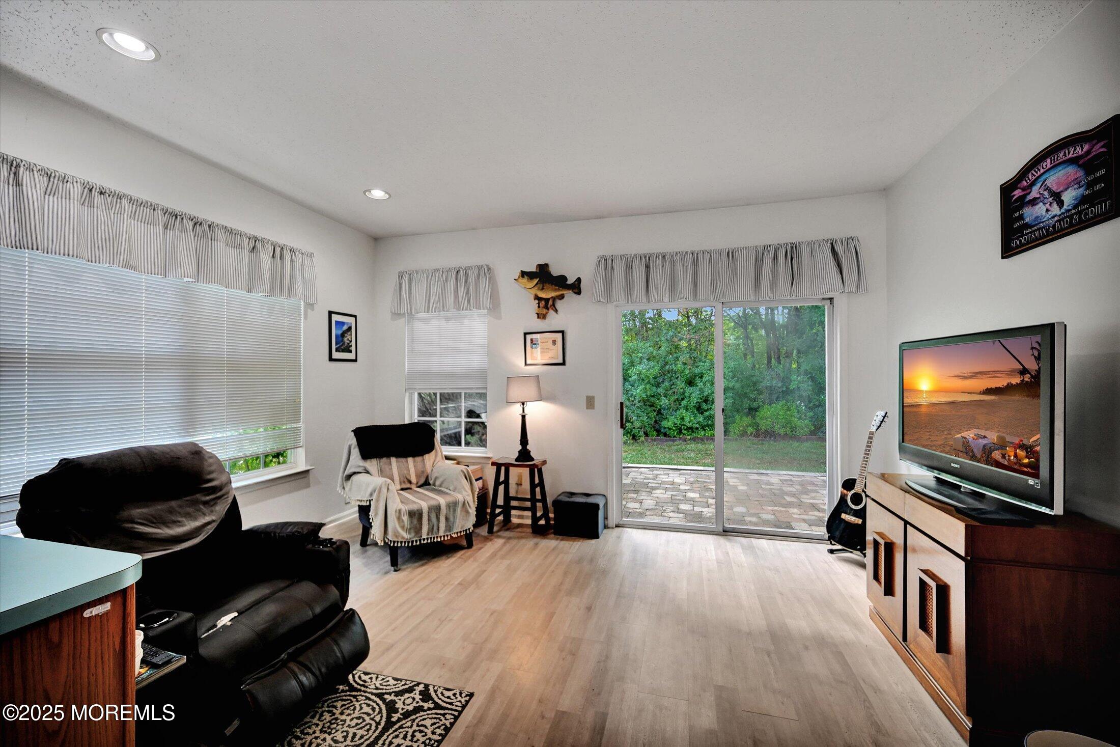 56 Quail Road Barnegat, NJ 08005 - Photo 11 of 30 a living room with furniture a flat screen tv and a floor to ceiling window