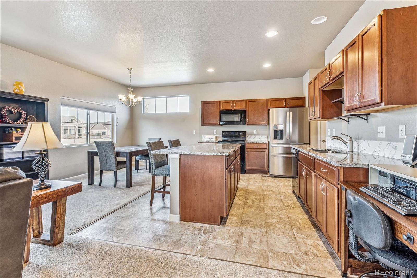 a large kitchen with stainless steel appliances lots of counter top space and furniture