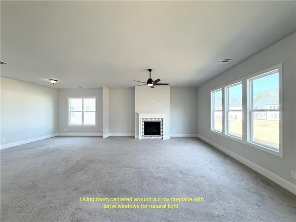 an empty room with a fireplace and windows