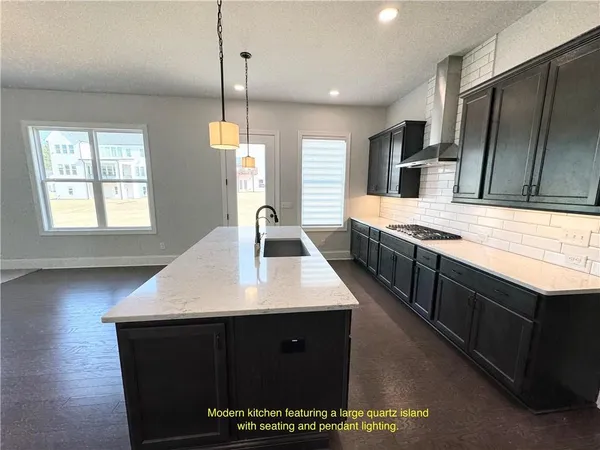 a kitchen with stainless steel appliances granite countertop a sink a stove a refrigerator and a oven