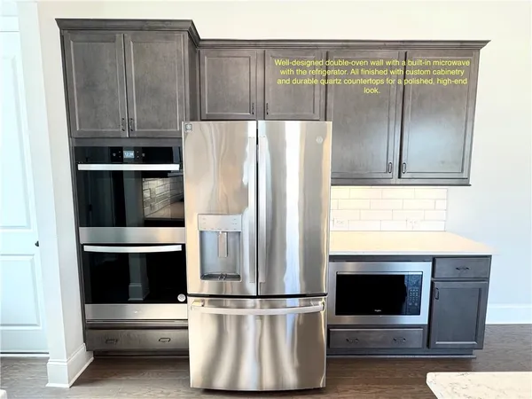 a kitchen with a refrigerator and white cabinets