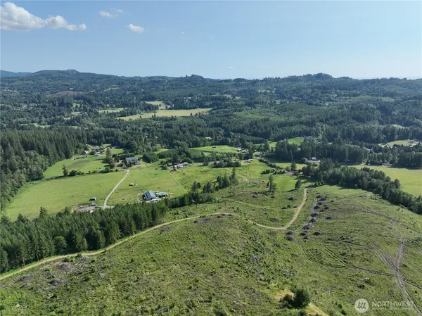 an aerial view of a houses with a lush green hillside