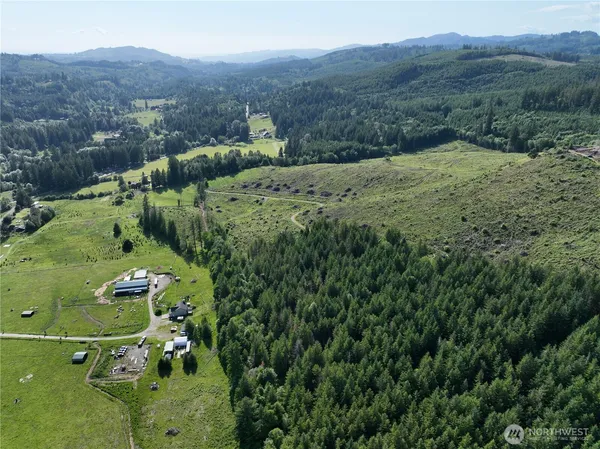 an aerial view of a houses with a lush green hillside