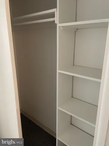 a view of walk in closet with empty racks