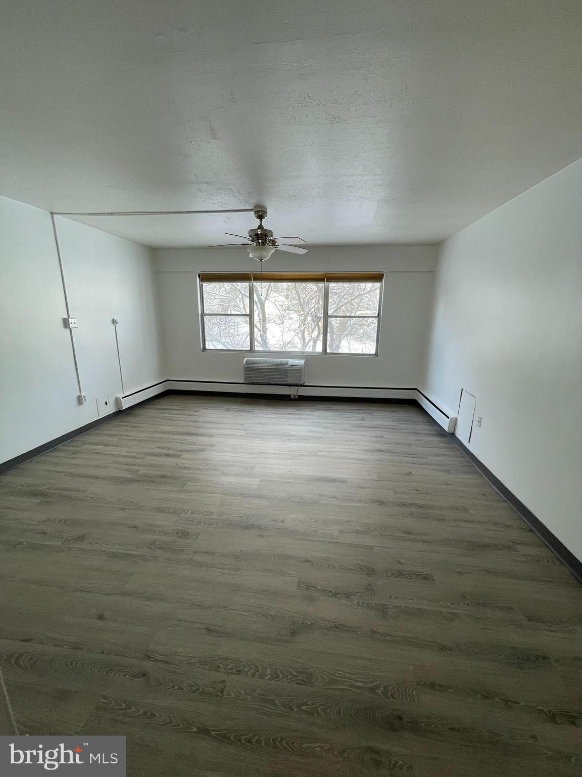 7900 Old York Road, Unit 311B Elkins Park, PA 19027 - Photo 6 of 22 an empty room with wooden floor and windows