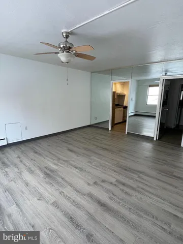 a view of a livingroom with wooden floor and a ceiling fan