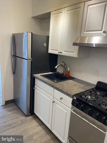 a kitchen with stainless steel appliances granite countertop a refrigerator stove and sink