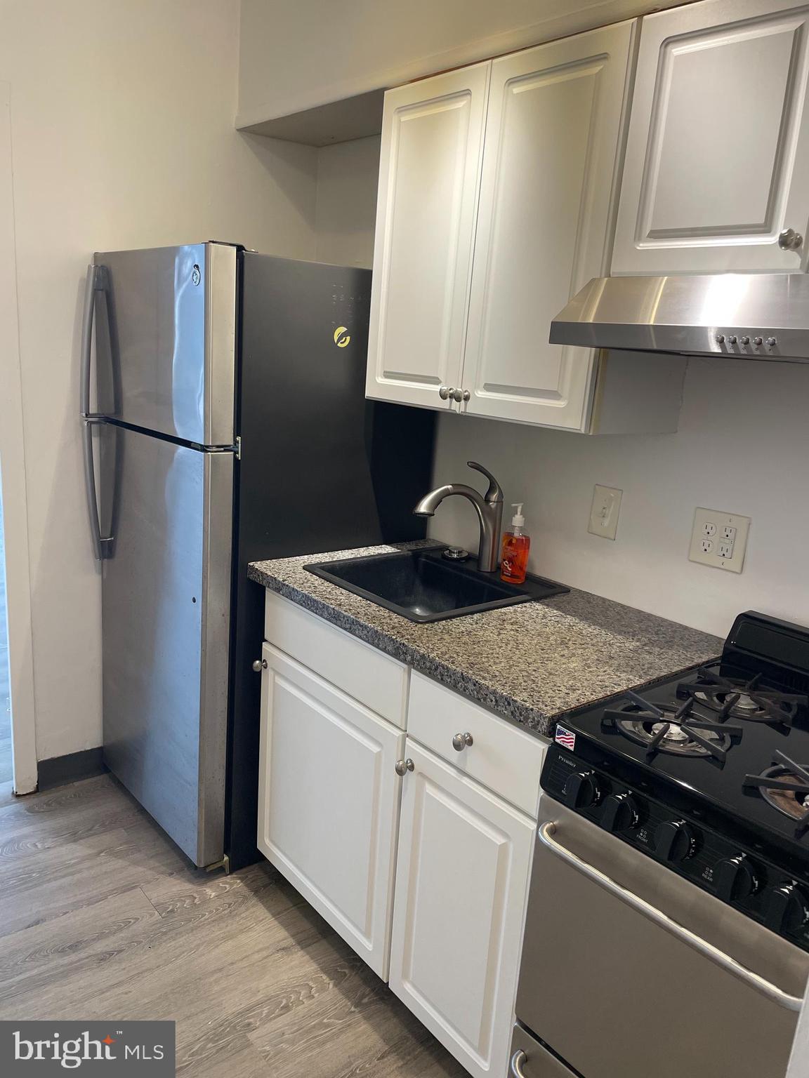 7900 Old York Road, Unit 311B Elkins Park, PA 19027 - Photo 10 of 22 a kitchen with stainless steel appliances granite countertop a refrigerator stove and sink