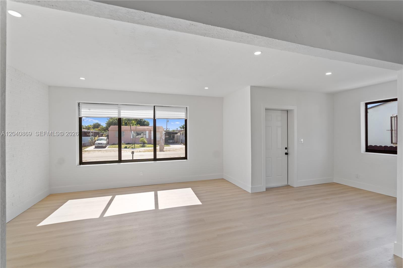 31 West 64th Street Hialeah, FL 33012 - Photo 11 of 49 a view of an empty room with wooden floor and a window
