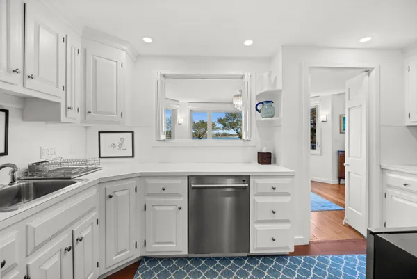 a kitchen with white cabinets and sink