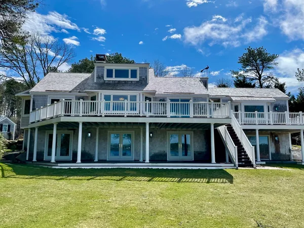 a view of a white house with a swimming pool and a yard