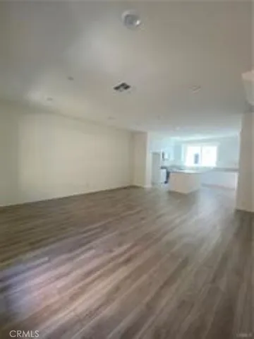 a view of empty room with wooden floor and windows