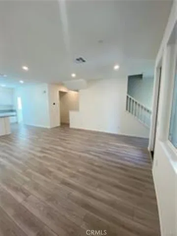 a view of an empty room with wooden floor