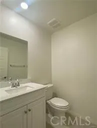 a bathroom with a granite countertop sink a toilet and a mirror