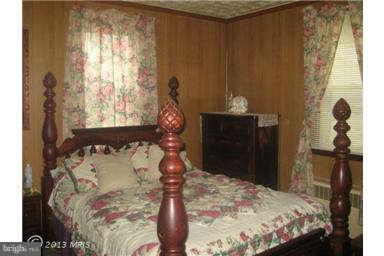 5630 Johnnycake Road Baltimore, MD 21207 - Photo 11 of 19 a bed sitting in a bedroom next to a window