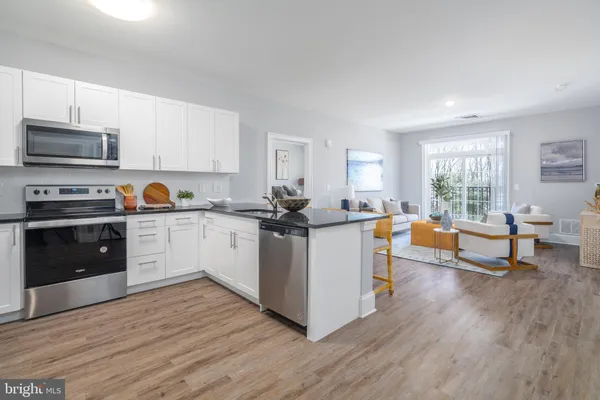 a kitchen with wooden floors and white cabinets