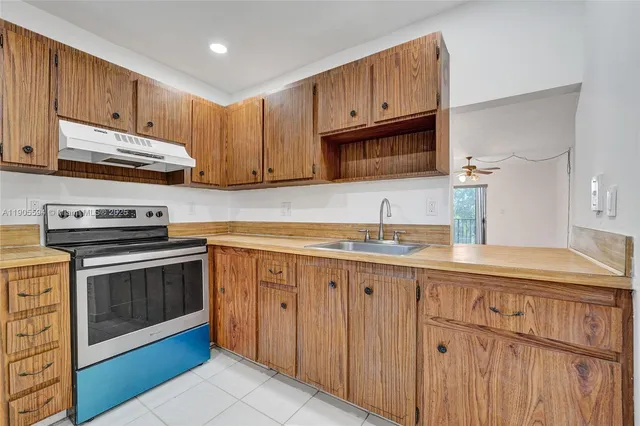 a kitchen with granite countertop cabinets stainless steel appliances and a sink