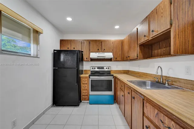 a kitchen with granite countertop a refrigerator and a sink
