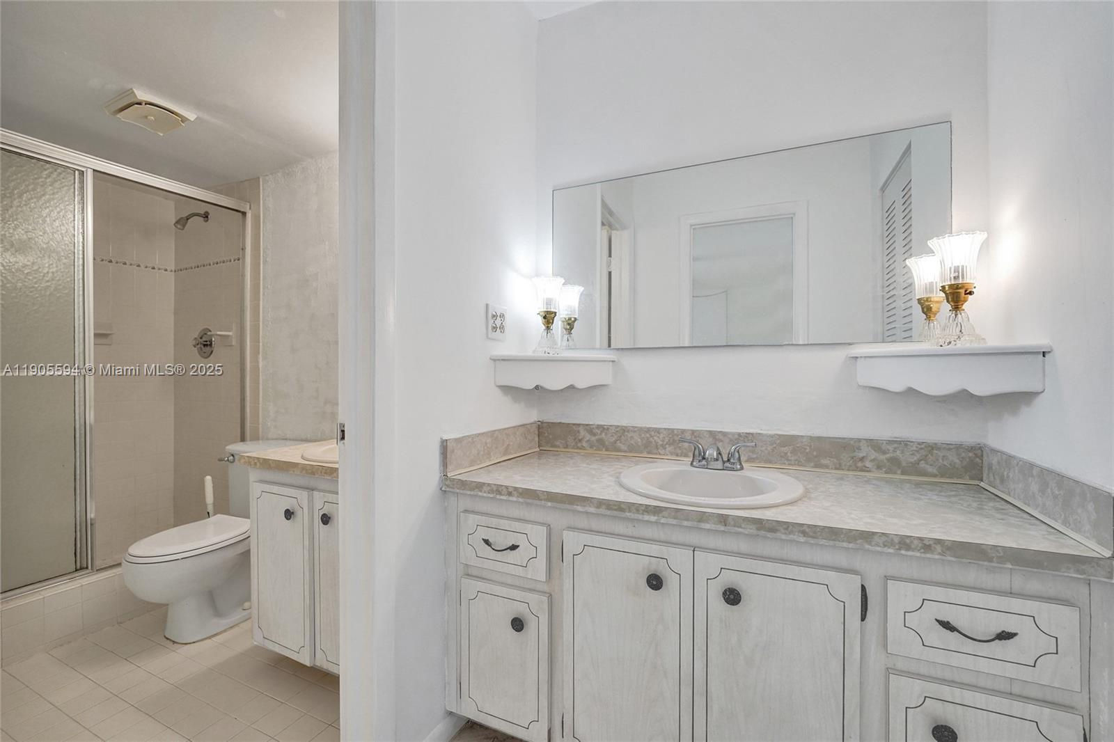 7541 Northwest 16th Street, Unit 1310 Plantation, FL 33313 - Photo 24 of 46 a bathroom with a granite countertop sink a toilet and a mirror