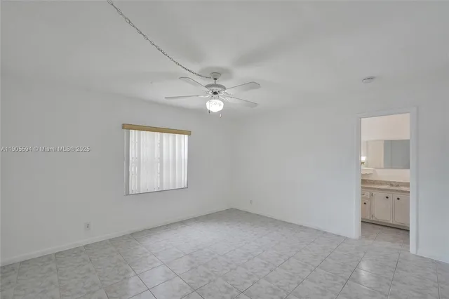 an empty room with closet and a ceiling fan