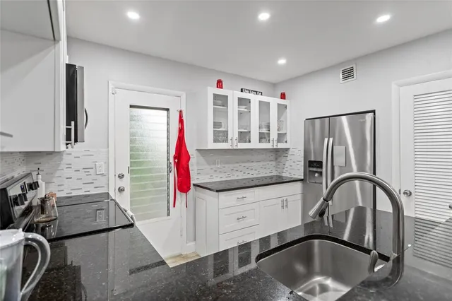 a kitchen with stainless steel appliances granite countertop a stove and a sink
