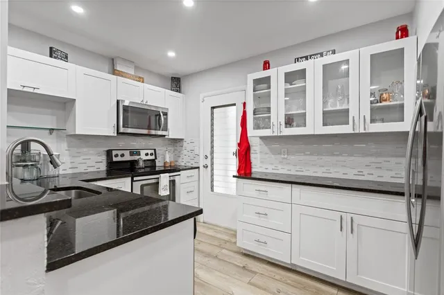 a kitchen with stainless steel appliances granite countertop a sink and a stove