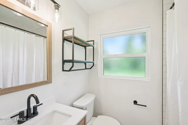 a bathroom with a toilet sink and mirror