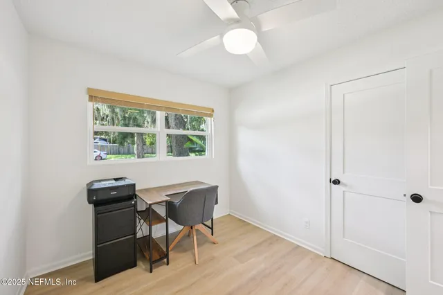 a view of a workspace with furniture and a window