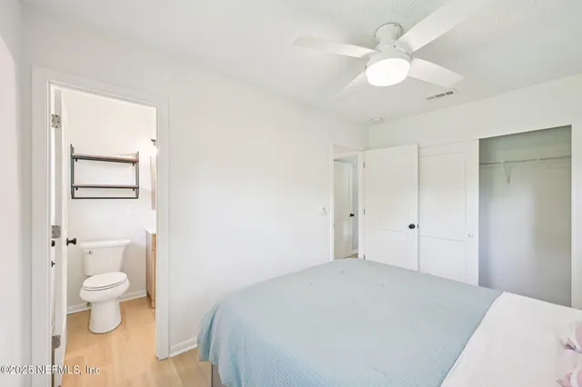 a spacious bedroom with a bed and a chandelier