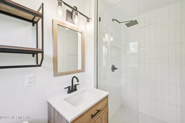 a bathroom with a sink a mirror and shower