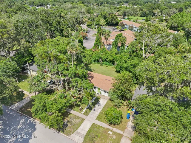 an aerial view of residential house with outdoor space and trees all around