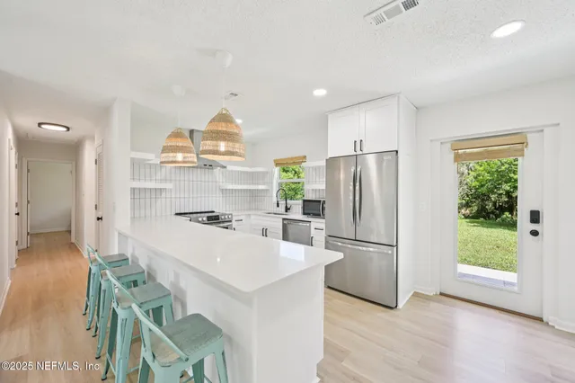 a kitchen with kitchen island a stove a refrigerator and a sink