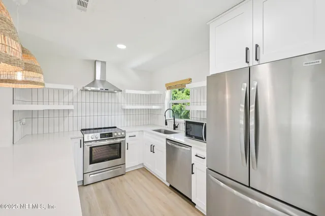 a kitchen with stainless steel appliances a refrigerator sink and stove