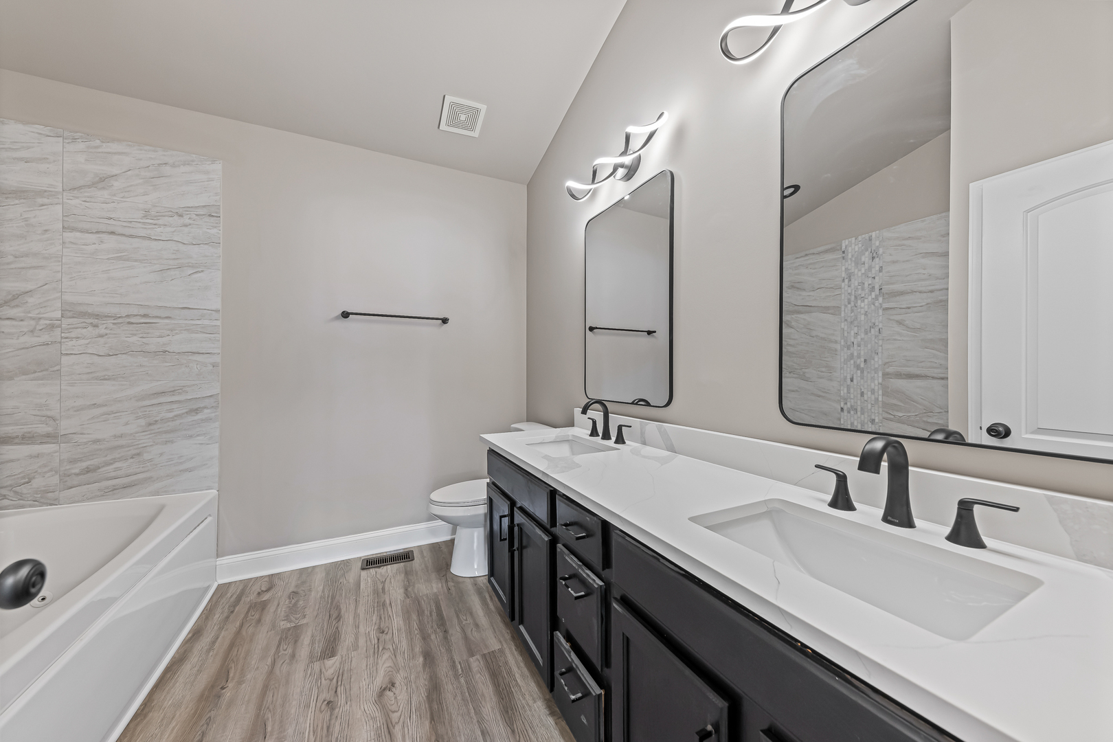 6006 West Carter Court Monee, IL 60449 - Photo 9 of 15 a bathroom with a double vanity sink a mirror and a bathtub