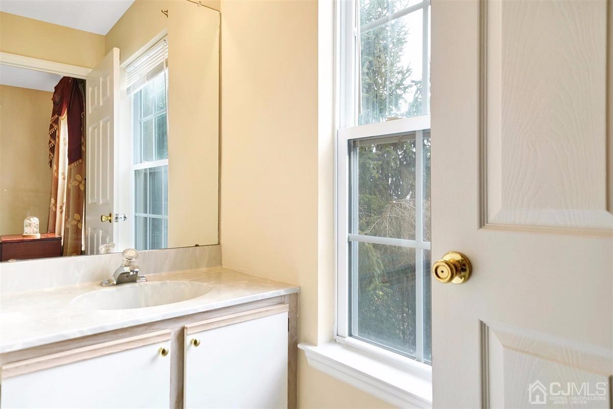 1 Prestwick Way, Unit 1 Edison, NJ 08820 - Photo 13 of 24 a bathroom with a granite countertop sink and a mirror