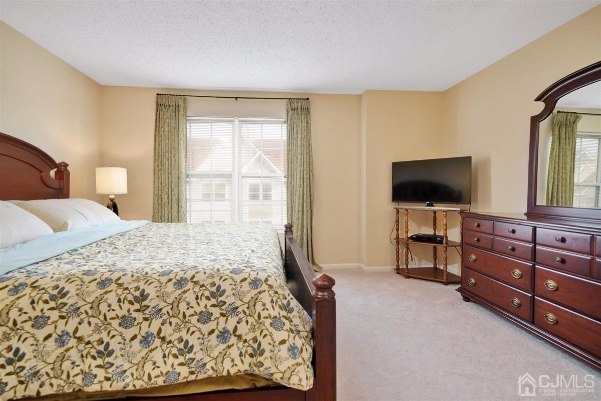1 Prestwick Way, Unit 1 Edison, NJ 08820 - Photo 15 of 24 a bedroom with a bed and a flat screen tv