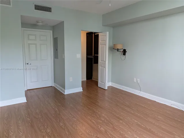 an empty room with wooden floor and closet