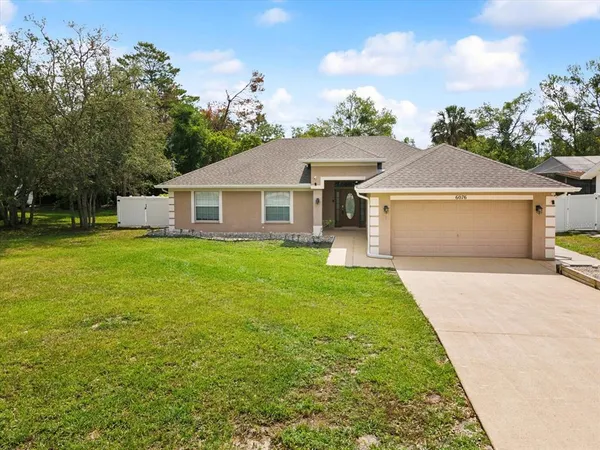 a view of a house with backyard and sitting area