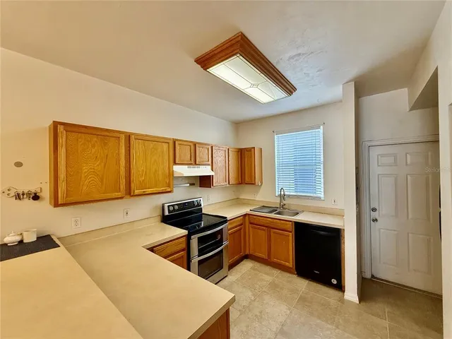 a kitchen with stainless steel appliances a sink a stove and a refrigerator