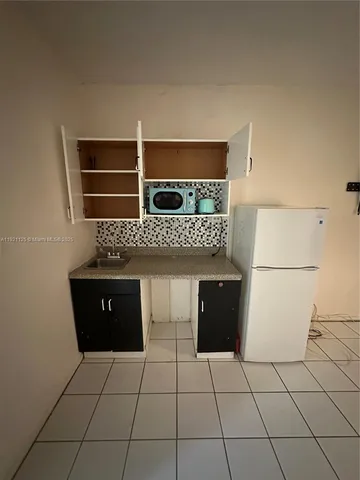a kitchen with a sink a stove and cabinets