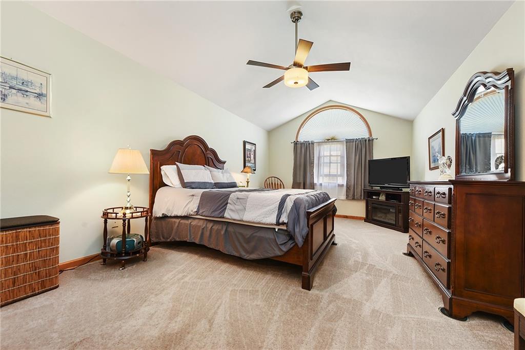 1069 Redoak Drive Harrison City, PA 15636 - Photo 24 of 43 a spacious bedroom with a bed a chandelier and a flat tv screen on dresser
