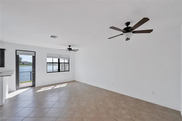an empty room with windows and ceiling fan