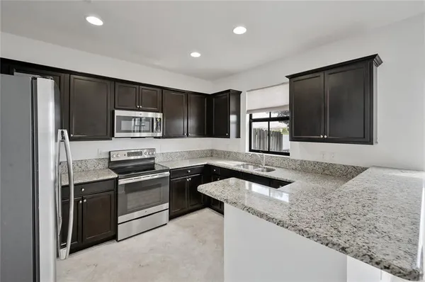 a kitchen with granite countertop stainless steel appliances and sink