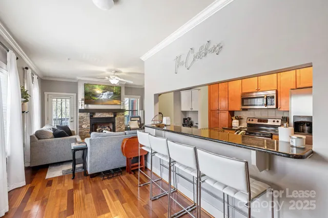 a living room with furniture a fireplace and a floor to ceiling window