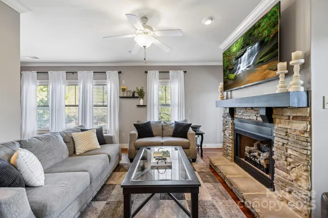 a living room with furniture a flat screen tv and a fireplace