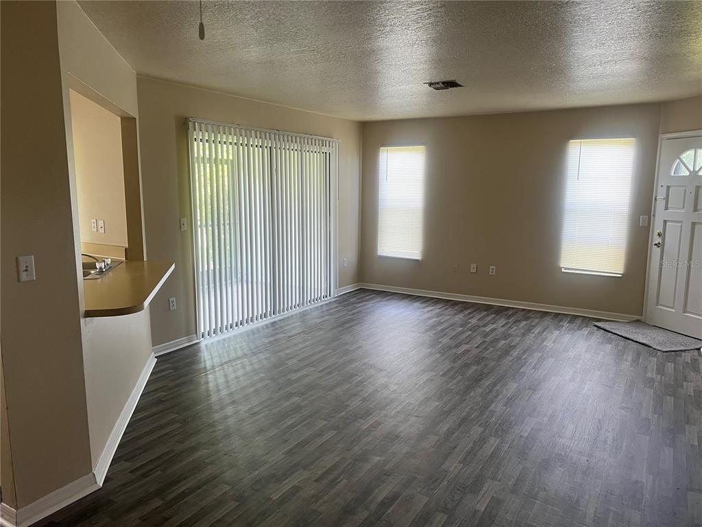 7266 Pond Circle Spring Hill, FL 34606 - Photo 14 of 15 an empty room with wooden floor and windows