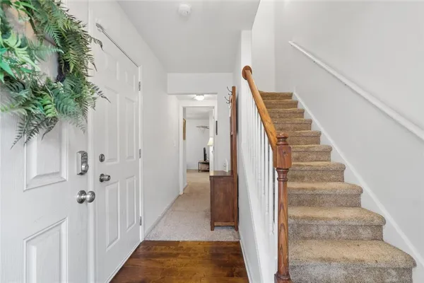 a view of a hallway with wooden floor and entryway