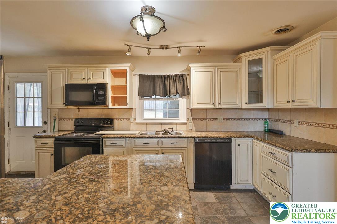 210 South 16th Street Emmaus, PA 18049 - Photo 13 of 71 a kitchen with kitchen island granite countertop a stove top oven microwave and cabinets